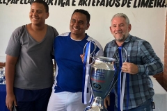 Presidente Betinho, entregando o Troféu de Vice Campeão para o representante da empresa Coremax, Márcio; seu filho ao lado.